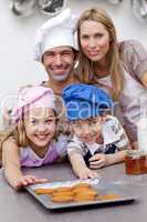 Happy children and parents eating cookies after baking