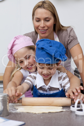 Mother and children baking cookies in the kitchen
