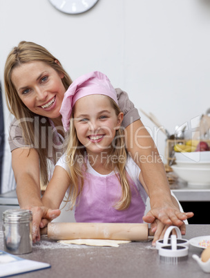 Mother and daughter baking Christmas cookies in the kitchen