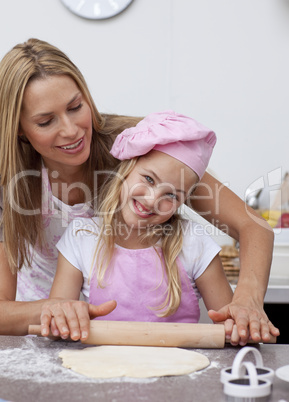 Happy mother and daughter baking in the kitchen