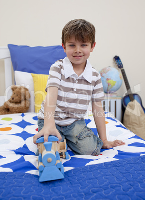 Little boy playing with a train in his bedroom