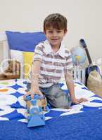 Little boy playing with a train in his bedroom