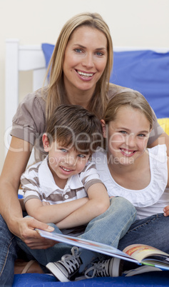 Portrait of mother reading a book with her children