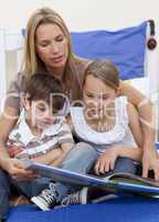 Mother reading a book with her children