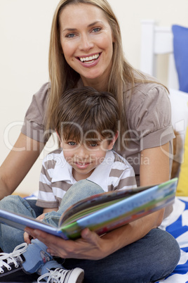 Smiling mother reading a book with her son