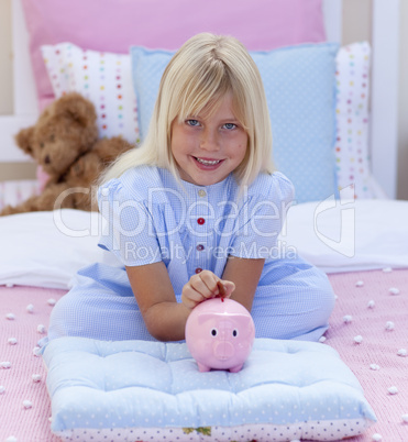Smiling girl saving money in a piggy bank