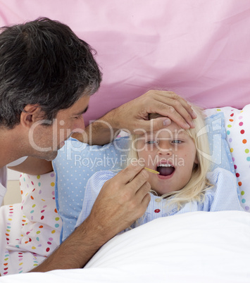 Father taking his daughter's temperature with a thermometer