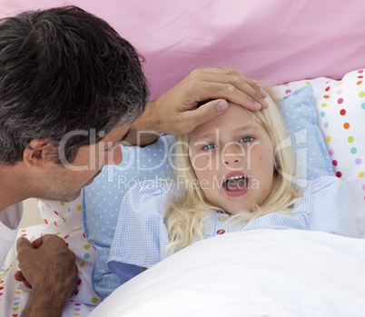 Father checking his daughter's temperature