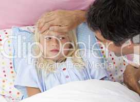 Father taking his daughter's temperature with a thermometer