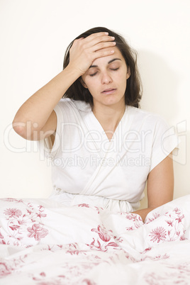 Frau mit Kopfschmerzen im Bett