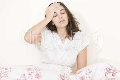 Frau mit Kopfschmerzen im Bett