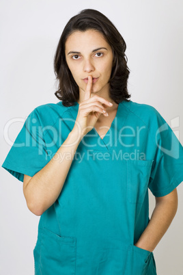 Krankenschwester im grünen Kittel bittet ums Schweigen