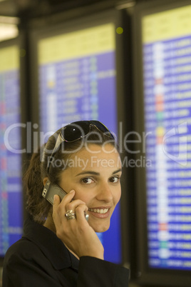 Hübsche Frau am Flughafen vor einem Informationsbildschirm