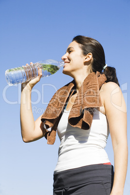 Junge Frau trinkt Wasser nach Sport