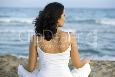 Frau macht Joga am Strand