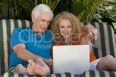 Senior Man and Woman Couple Outside Using Laptop Computer