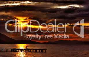 hdr sunset with dramatic clouds and pier