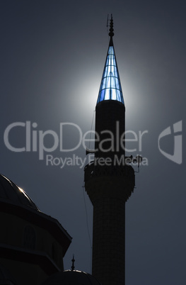 Turkish mosque at dusk with sunlight behind turret