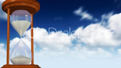 Rotating hourglass with clouds in the background.