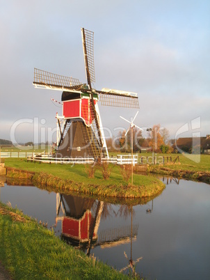 Red windmill in autumn sun