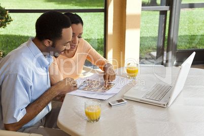 African American Couple Using Laptop Computer To Surf The Intern
