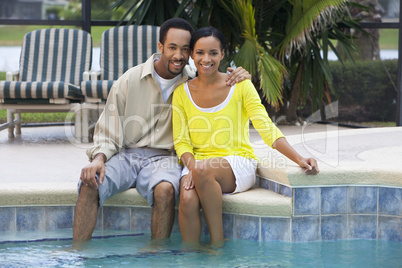 Happy African American Couple Sitting Outside Next To Swimming P