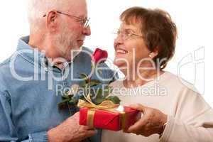 Happy Senior Couple with Gift and Red Rose