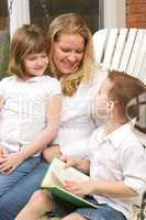 Young Boy Reads to His Mother and Sister