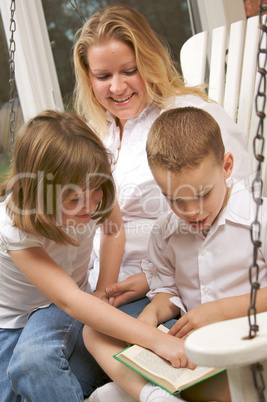 Young Boy Reads to His Mother and Sister