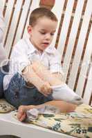 Adorable Young Boy Getting Socks On