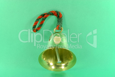 Hand bell over green background.