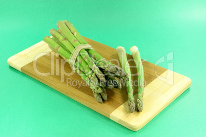 Pile of asparagus over green background.