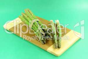 Pile of asparagus over green background.