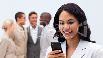 Smiling ethnic businesswoman sending a text