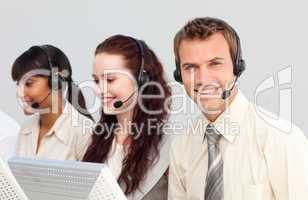 Smiling young businessman working in a call center