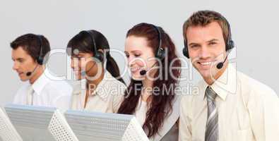 Smiling attractive businessman working in a call center