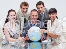 Smiling business team holding a terrestrial globe