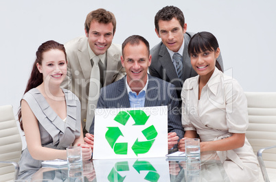 Smiling business team holding a recycling symbol. Ecological bus