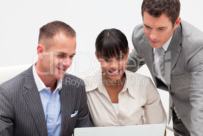 Businesswoman and businessmen using a laptop in the office