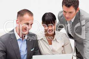 Businesswoman and businessmen using a laptop in the office