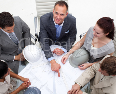 Architect manager pointing at a blueprint in a meeting