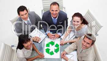 High angle of smiling business team holding a recycling symbol