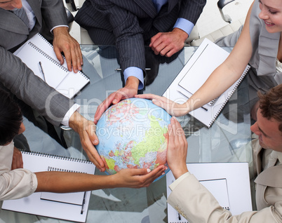 High angle of business team holding a terrestrial globe