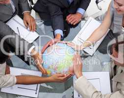 High angle of business team holding a terrestrial globe