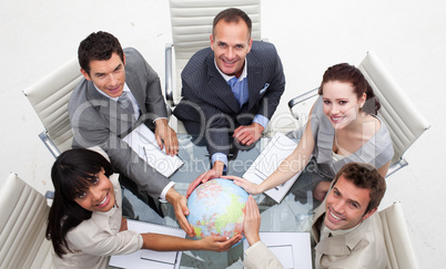 High angle of smiling business team holding the world