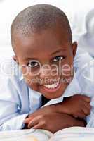 Young boy lying on his bed smiling