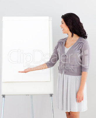 Business woman smiling and pointing at presentation Board