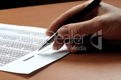 hand with black pen sign the document