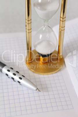 Sand-glass with the pencil and a notebook