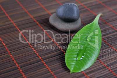 Stones with green sheet on a bamboo napkin